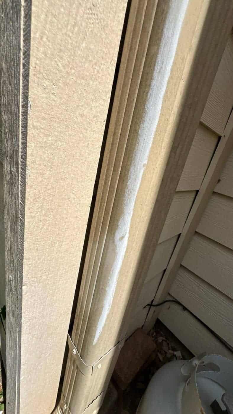 Close-up of a caulked corner trim seam on painted fibre-cement siding