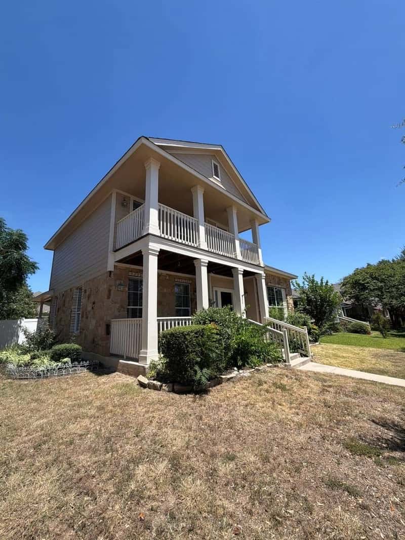 Full front elevation of a craftsman-style home with stacked porch roofs and stone accents
