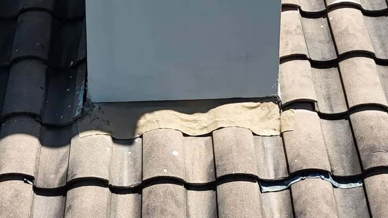 Sealant applied along step flashing where tile roofing abuts a stucco wall