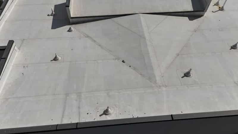 Close aerial detail of TPO membrane seams and pipe boots on a commercial roof